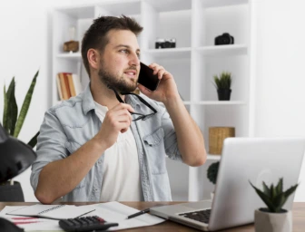 Muž telefonuje u pracovního stolu